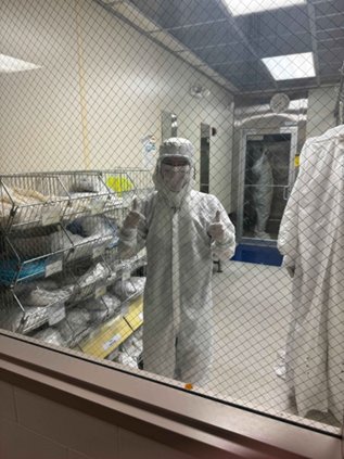 Ethan in a cleanroom suit inside the micro/nano fabrication cleanroom