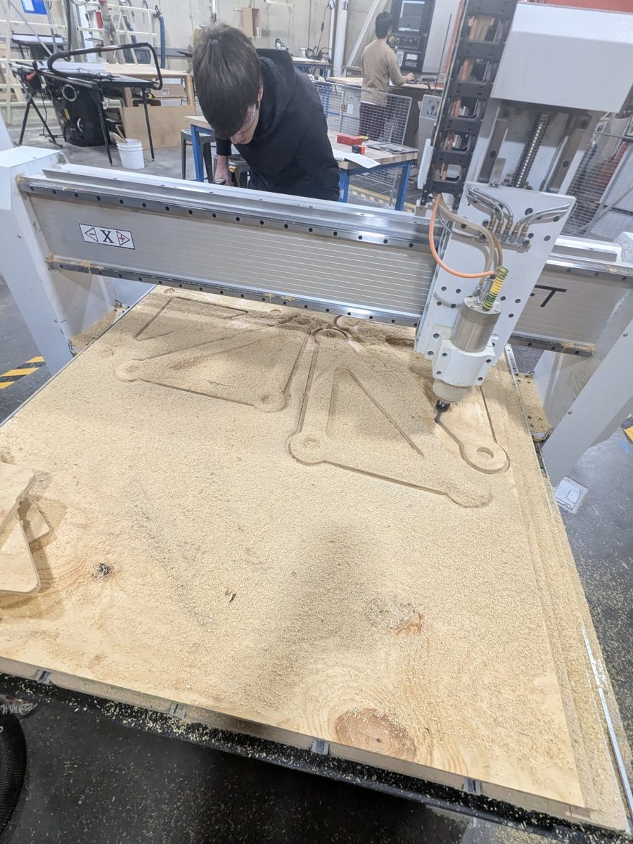 CNC router cutting leg links out of a plywood sheet